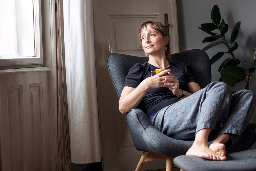Eszter Farkas sitting with a warm drink in a cosy room.